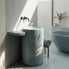 Oasis freestanding concrete basin SNK140 in Sea Shade colour with full-length integrated side shelf and organic cylinder form against dark wall