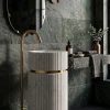 Muniq freestanding fluted white marble full column pedestal basin with 2 brushed gold rings and gold floor faucet in dark luxury bathroom