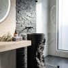 Torn layered black artificial stone freestanding cylinder pedestal basin 1335 with fine horizontal ribbon striations and dramatic matte black torn fractured exposed section