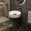 Sunburst white marble effect artificial stone freestanding pedestal basin with radiating ribbed bowl on black white striped fluted column in dark luxury bathroom