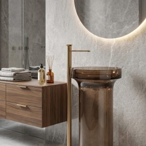 Muniq transparent bronze resin freestanding basin 460x850mm translucent amber bronze cylinder pedestal sink with flat rim bowl and brushed gold floor standing tap on marble surface
