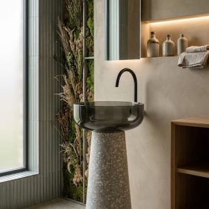Muniq terrazzo resin freestanding basin 7108 400x830mm showing warm grey and white terrazzo effect tapered cone pedestal with contrasting wide smoked black glossy round bowl luxury washbasin