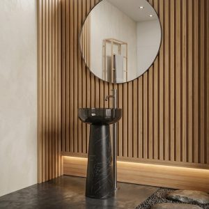 Muniq black marble effect resin freestanding basin in moody industrial luxury bathroom with exposed brick wall raw concrete panels Edison pendant lights and frameless round mirror