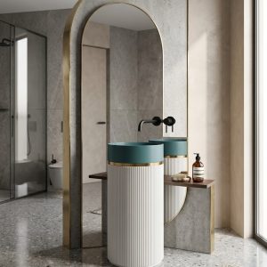 Artificial stone freestanding fluted pedestal basin 1301 with deep teal bowl gold connecting ring and white vertically fluted column in luxury bathroom with gold arch mirror