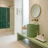 Aquilo countertop concrete cylinder basin SNK130 in sage green on matching concrete vanity surface in luxury bathroom with emerald green wall tiles and gold fixtures