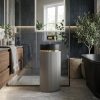 Muniq artificial stone pedestal basin with grey fluted cylinder pedestal matte black bowl and gold ring accent in contemporary bathroom with dark slate tiles timber vanity and indoor plants