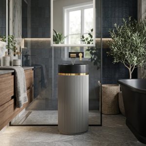 Muniq artificial stone pedestal basin with grey fluted cylinder pedestal matte black bowl and gold ring accent in contemporary bathroom with dark slate tiles timber vanity and indoor plants