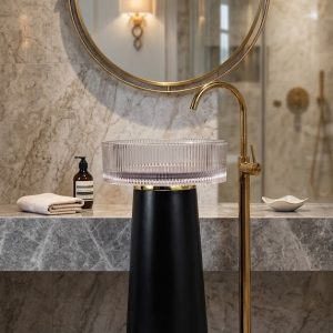 Muniq matte black resin freestanding basin with fluted crystal resin bowl and brushed gold ring in five star hotel luxury bathroom with marble wall cladding gold floor tap and round gold mirror