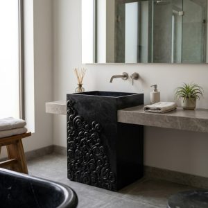Muniq freestanding Indian black stone baroque carved basin with deep hand-carved scroll relief exterior and rectangular integrated bowl in contemporary luxury bathroom