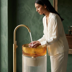 Front view of luxury amber crystal glass pedestal basin featuring ribbed glass detailing and transparent cylindrical base
