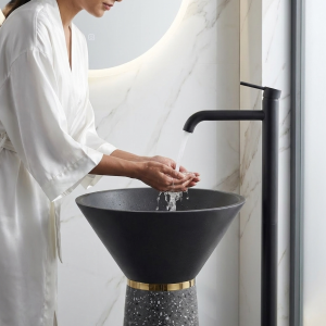 Close-up of dramatically flared matte black cone bowl and precision gold ring accent on Muniq artificial stone pedestal basin 1328 grey terrazzo tapered column washbasin