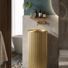 Flute Gold freestanding stainless steel pedestal basin with brushed gold PVD fluted cylinder form glowing warm gold in dark bathroom with chevron tiles and round LED mirror