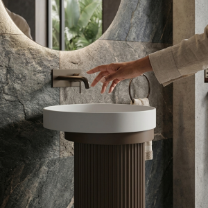 Close-up of clean brilliant white round bowl sitting flush with mocha bronze fluted pedestal of Muniq artificial stone pedestal basin 1315 showing balanced colour transition