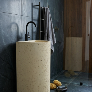 Luna freestanding concrete pedestal basin SNK100 in Garlic Pod colour with pitted and smooth dual finish and black matte gooseneck faucet against exposed brick wall