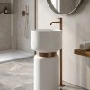White artificial stone freestanding mushroom pedestal basin with matte white rounded bowl polished bronze connecting ring and bronze floor faucet in calm luxury bathroom