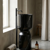 Muniq freestanding Nero Marquina goblet basin black marble hourglass pedestal sink with deep mirror polish finish and bold white calcite veining in luxury bathroom