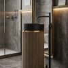 Muniq artificial stone pedestal basin with sand beige fluted cylinder pedestal matte black bowl and gold ring accent in moody luxury bathroom with brass framed mirror and dark stone walls
