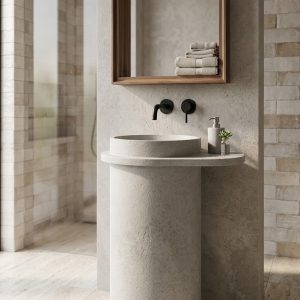 : Florence freestanding concrete tapered cylinder pedestal basin with wide flat rim and deck-mounted black faucet in grey colour