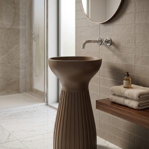 Muniq artificial stone pedestal basin 1340 400x850mm showing warm bronze brown fluted hourglass goblet silhouette with concave waist and smooth flared bowl sculptural luxury washbasin
