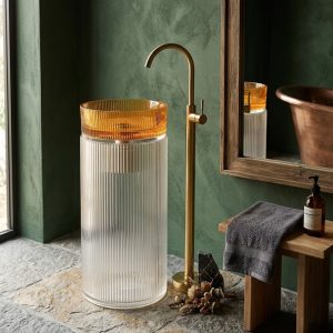 Amber crystal glass pedestal freestanding basin with transparent fluted glass column and amber ribbed glass bowl paired with brushed gold faucet