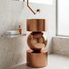 Muniq SS Globe rose gold sphere basin 108 with matte rose gold stainless steel drum base mirror-polished rose gold sphere and matching drum bowl against dark slate herringbone tile wall