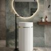 Muniq artificial stone pedestal basin 1301 400x860mm showing white fluted cylinder pedestal with deep teal bowl section and gold ring accent in contemporary bathroom with oval mirror