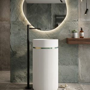 Muniq artificial stone pedestal basin 1301 400x860mm showing white fluted cylinder pedestal with deep teal bowl section and gold ring accent in contemporary bathroom with oval mirror