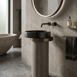 Luxury black stone vessel basin mounted on a wood-textured cylindrical pedestal with metallic accent ring in a modern designer bathroom.