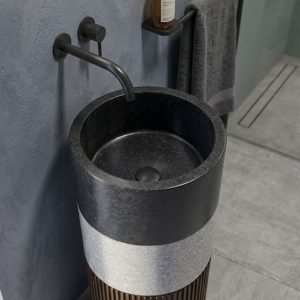 Close-up view of decorative vertical fluting on the pedestal base of a contemporary composite stone basin.