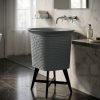 Composite stone vessel basin featuring a geometric honeycomb texture exterior mounted on a contemporary black metal stand.