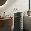 Dark grey terrazzo composite stone freestanding basin with textured cylindrical pedestal and elegant gold accent ring.