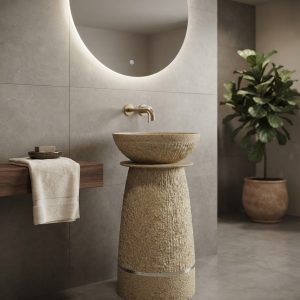 Beige terrazzo composite stone freestanding basin with sculpted bowl, textured tapered pedestal, and metallic accent ring.